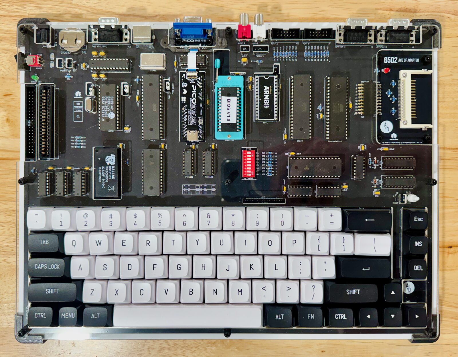 An ACE from above: one black circuit board carrying every chip, with a 67-key keyboard along the front and connectors across the back.