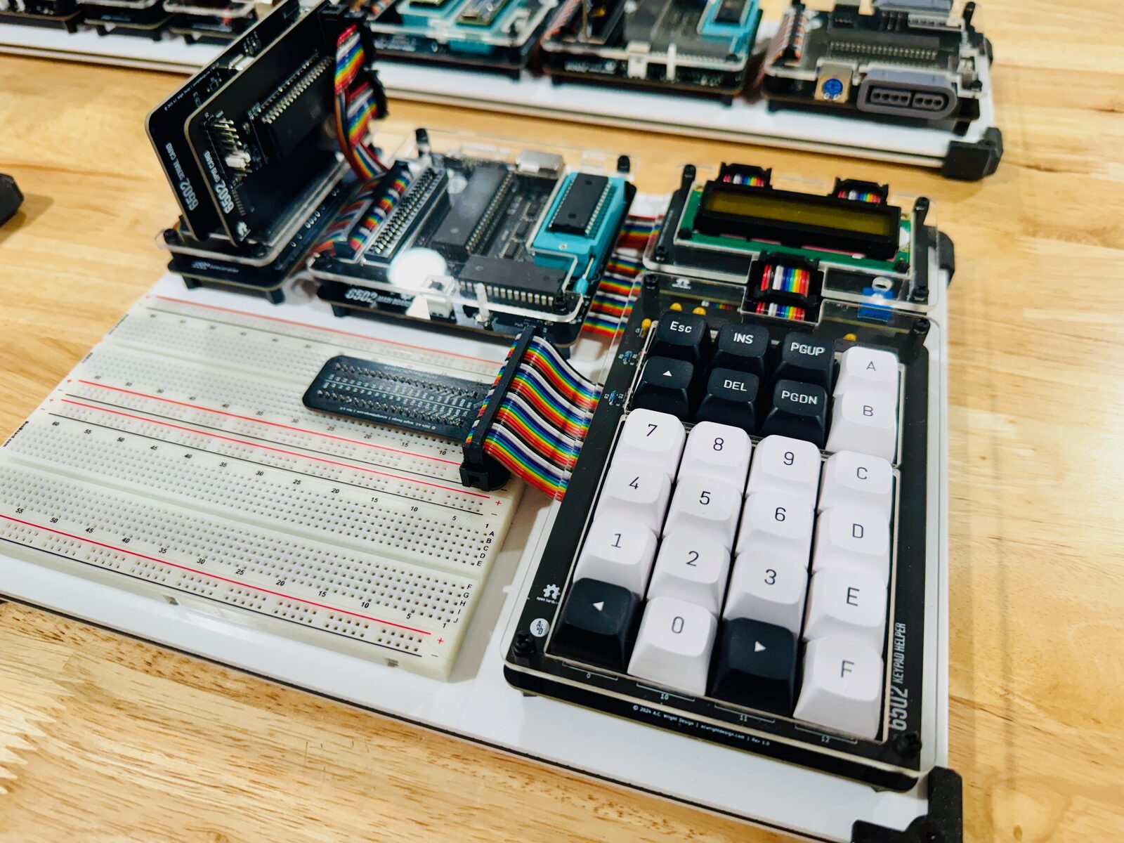 A keypad of 24 keys wired by ribbon cable to a small board carrying a two-line LCD, both connected to a 6502 main board.
