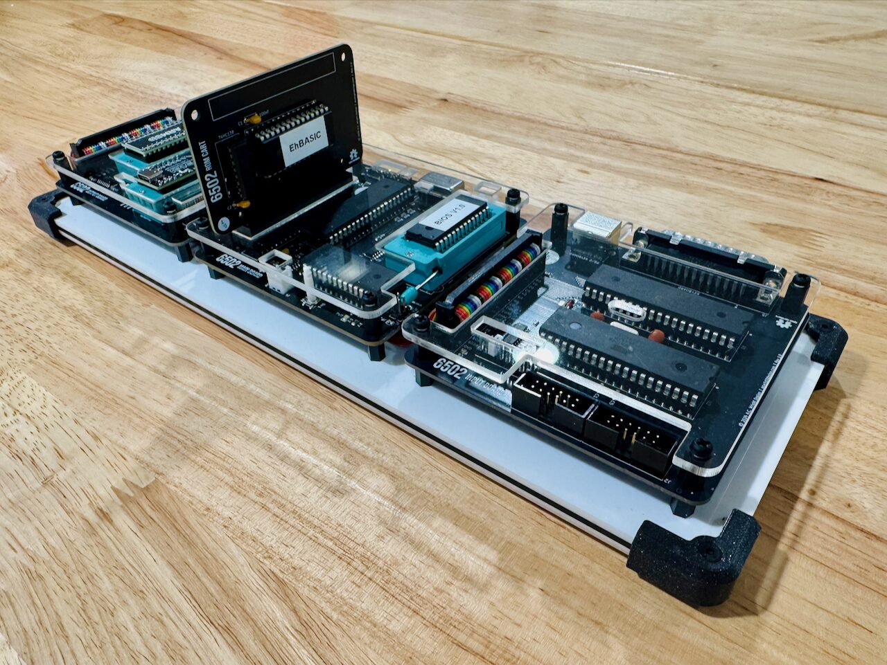 Three boards on a plate with a ROM cartridge standing upright in a slot at the front, its label reading EhBASIC.